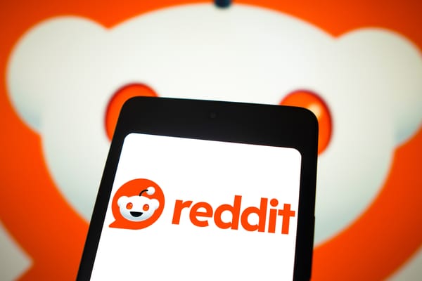 The Reddit logo and wordmark shown on a smartphone.