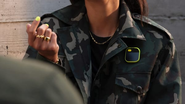 The Humane pin worn by a woman in a camoflauge jacket.