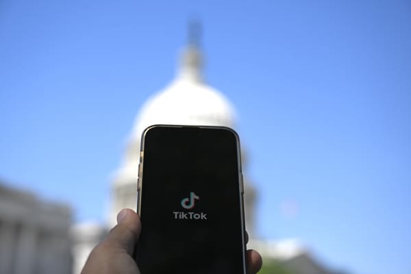 Photo illustration of TikTok is displayed on a mobile phone screen in front of The White House